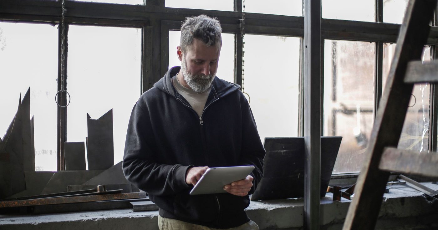 A tradesman with a tablet in his workshop