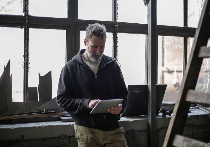 A tradesman with a tablet in his workshop